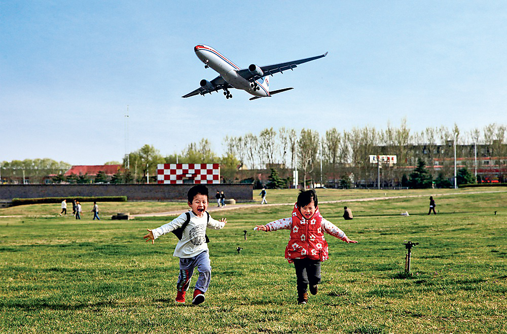 《兄妹要与飞机比高低》 小学组  摄影：李诚成.jpg